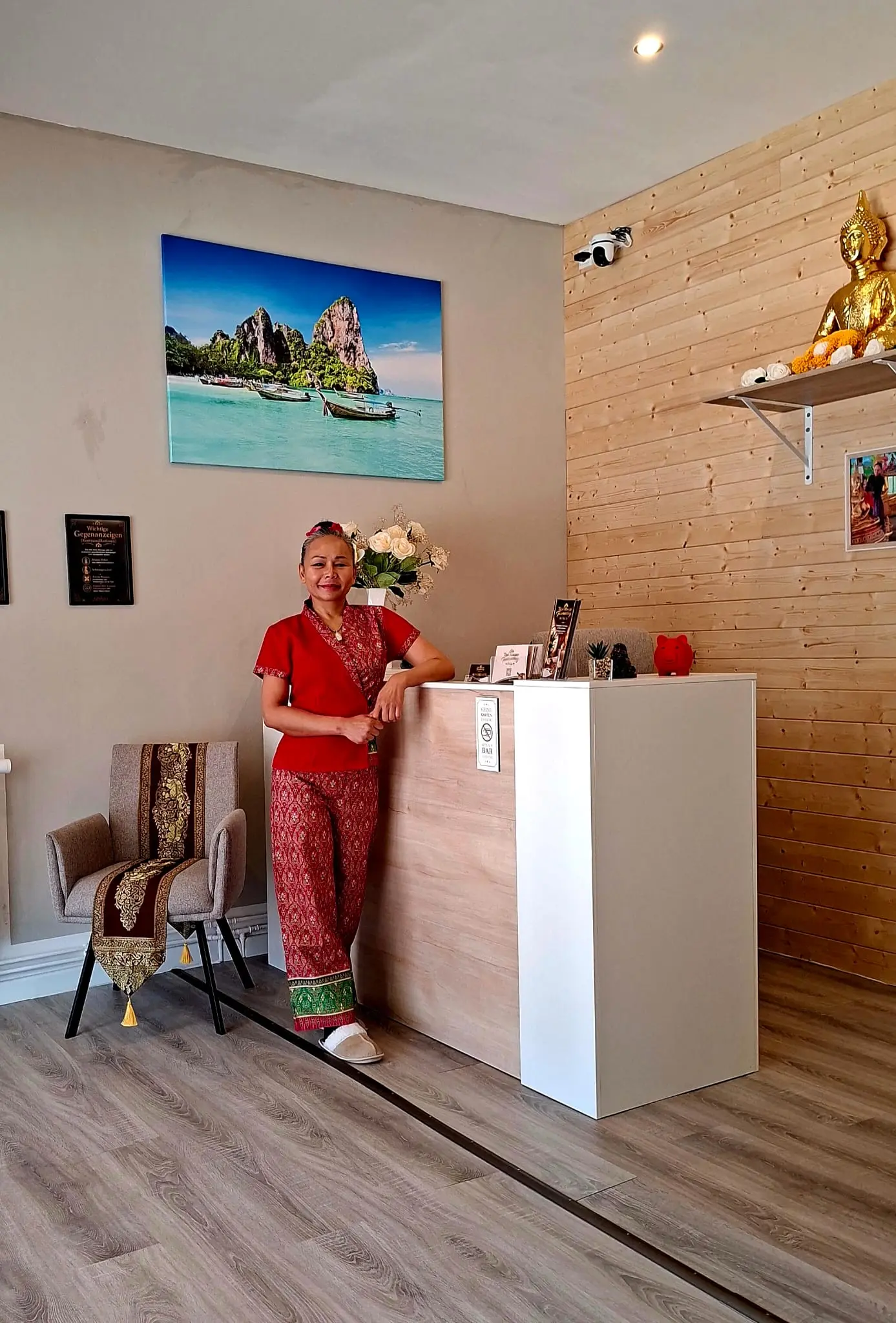 Tawanchay Witt am Empfangstresen, umgeben von thailändischer Deko